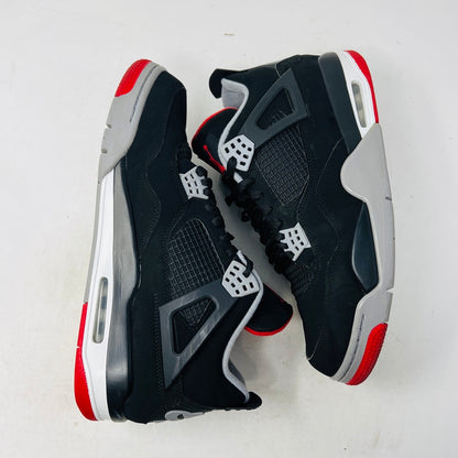 A pair of Jordan 4 Retro Bred (2019) sneakers with clean uppers are shown on a shoebox. These black and gray shoes have red accents, a visible Air unit, and rest on a speckled gray box featuring the red Jumpman logo. Available sizes include 12 and 13.5.