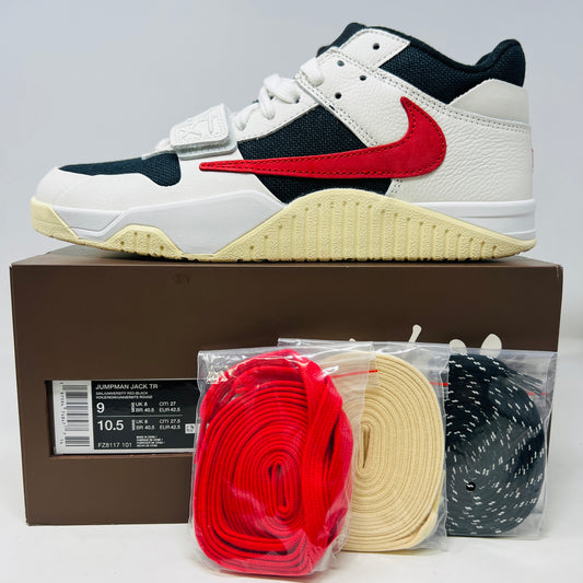 The Jordan Jumpman Jack TR Travis Scott University Red sneakers, black and white with red swooshes, rest on a brown shoe box. Three lace sets in red, cream, and black with white speckles are individually packaged in front. The box label displays sizes 9 and 10.5.