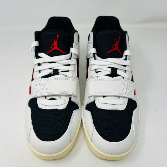 The Jordan Jumpman Jack TR Travis Scott University Red sneakers, black and white with red swooshes, rest on a brown shoe box. Three lace sets in red, cream, and black with white speckles are individually packaged in front. The box label displays sizes 9 and 10.5.