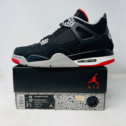 A pair of Jordan 4 Retro Bred (2019) sneakers with clean uppers are shown on a shoebox. These black and gray shoes have red accents, a visible Air unit, and rest on a speckled gray box featuring the red Jumpman logo. Available sizes include 12 and 13.5.