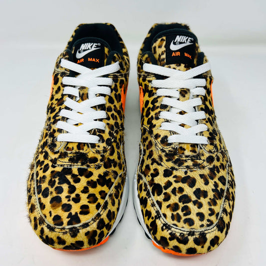 The Nike Air Max 1 Atmos Animal 3.0 Leopard features a leopard print with an orange swoosh, white laces, and a visible air cushion in the sole. It boasts black and orange tread and clean uppers for sleek appeal.