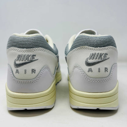 The Nike Air Max 1 Patta Waves White sneaker, size 12, sits on its box with Nike and Patta logos. VNDS white laces and a red Patta tag are in front, verifying its genuine.