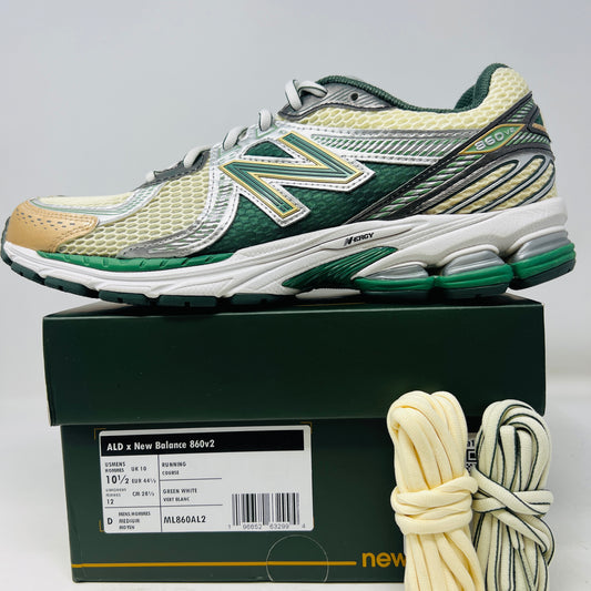 The New Balance 860v2 Aime Leon Dore Green sneaker, with mesh and leather uppers, features green and beige accents. Displayed on its box, it comes with cream and yellow laces for an authentic look.