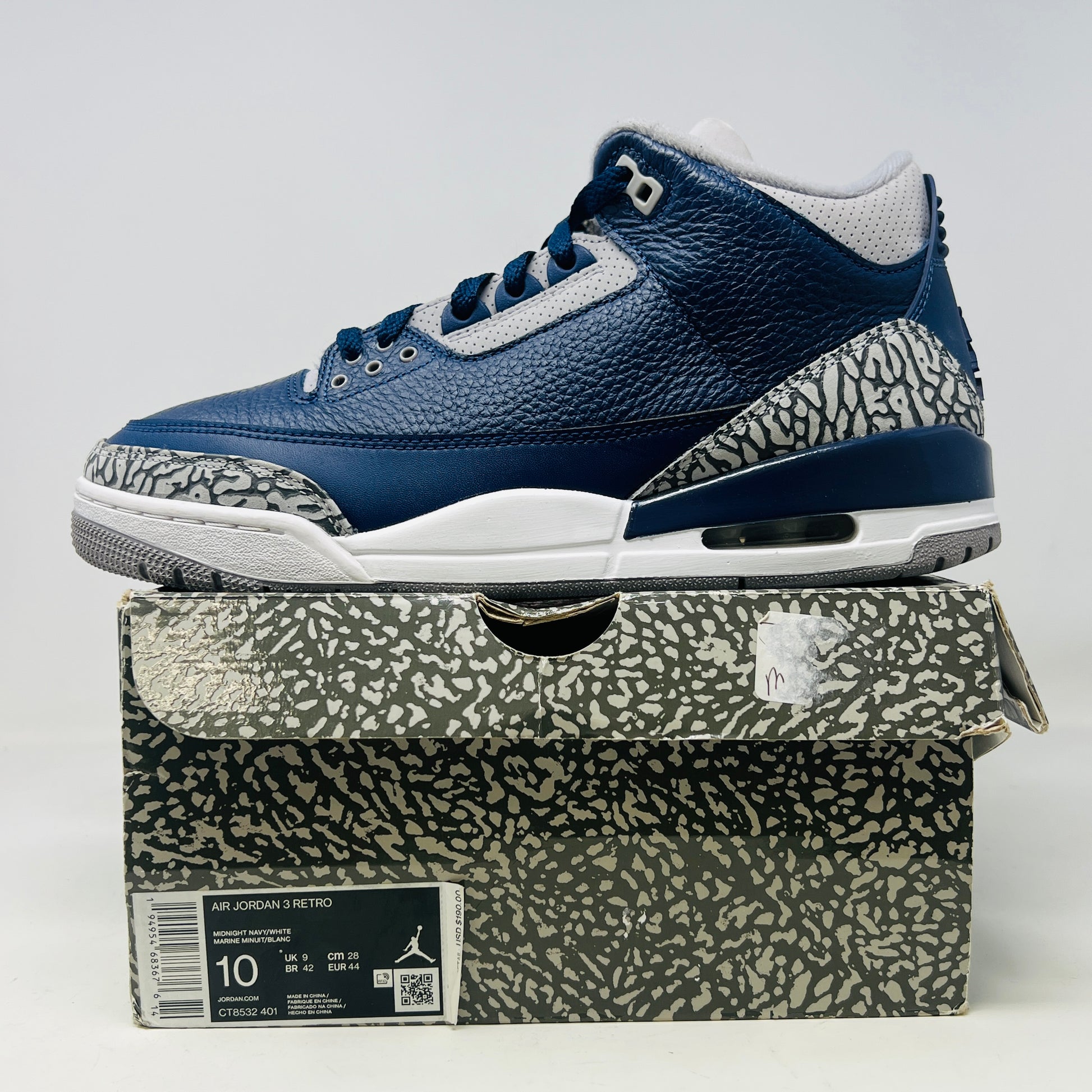 A size 10 Jordan 3 Retro Georgetown (2021) sneaker, in blue and gray with elephant print accents and a white midsole, worn once on its patterned box. The box has minor DMG but matches the sneakers stylish appeal.