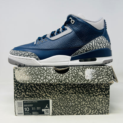 A size 10 Jordan 3 Retro Georgetown (2021) sneaker, in blue and gray with elephant print accents and a white midsole, worn once on its patterned box. The box has minor DMG but matches the sneakers stylish appeal.