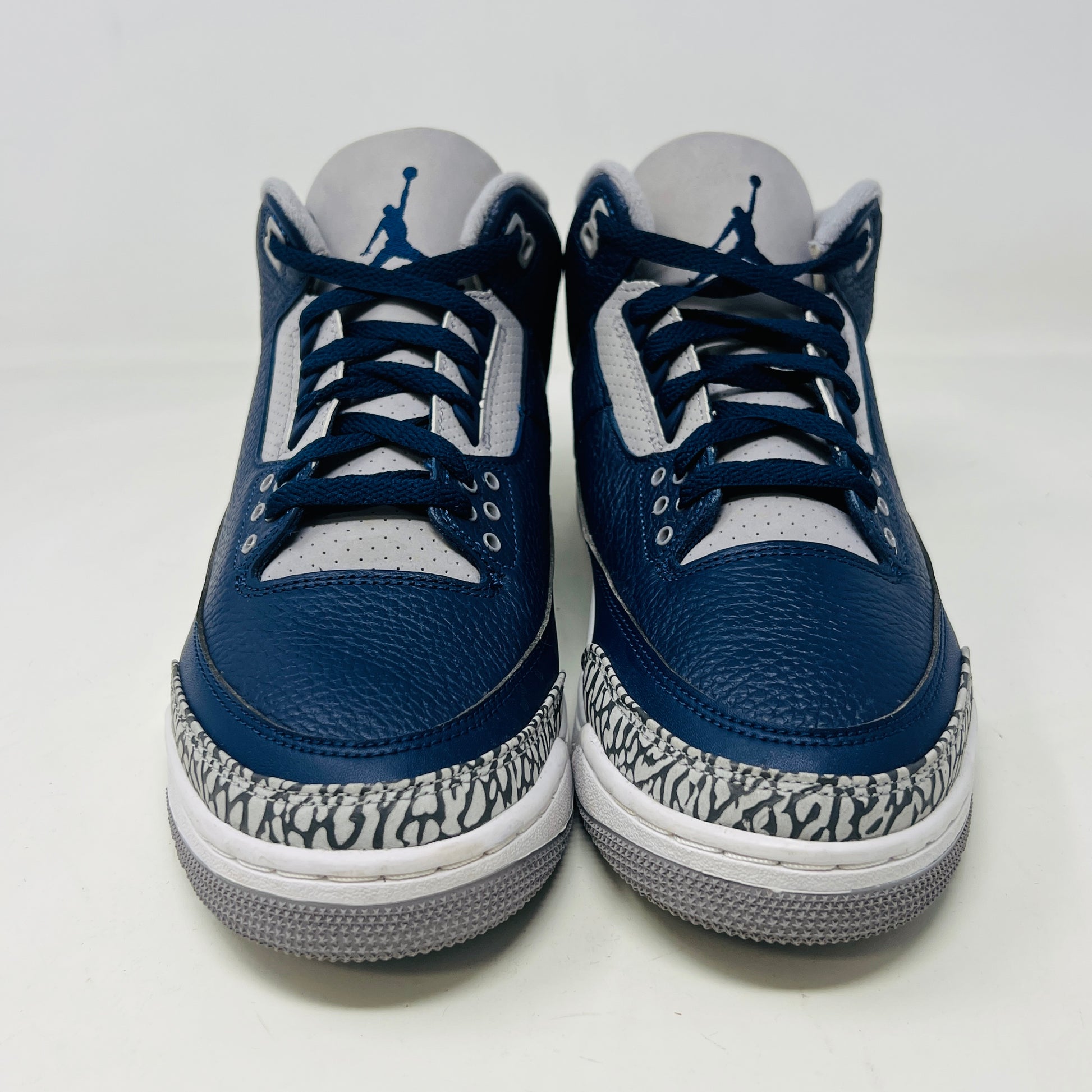 A size 10 Jordan 3 Retro Georgetown (2021) sneaker, in blue and gray with elephant print accents and a white midsole, worn once on its patterned box. The box has minor DMG but matches the sneakers stylish appeal.