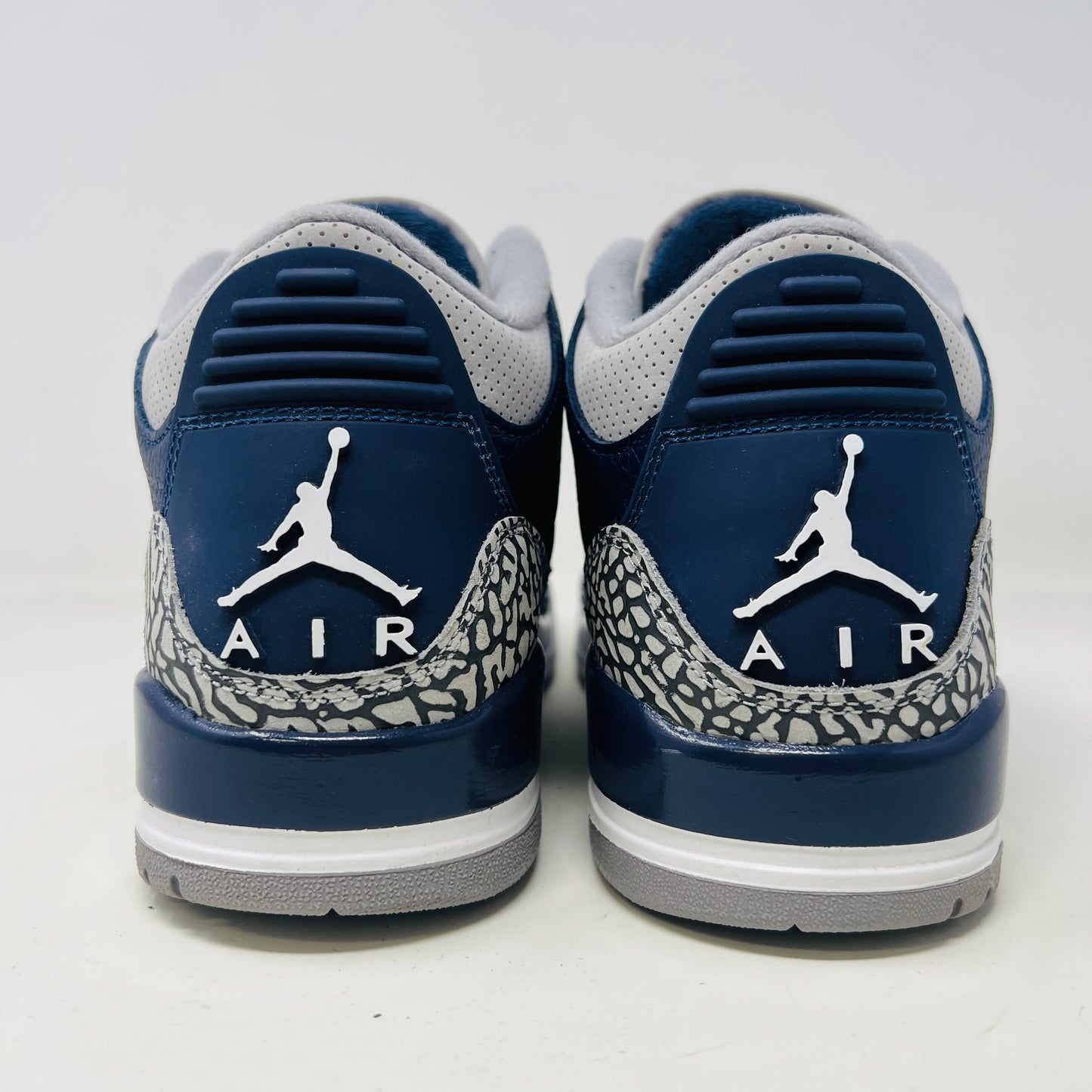 A size 10 Jordan 3 Retro Georgetown (2021) sneaker, in blue and gray with elephant print accents and a white midsole, worn once on its patterned box. The box has minor DMG but matches the sneakers stylish appeal.