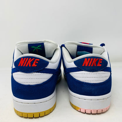 A pair of genuine 2022 Nike SB Dunk Low Los Angeles Dodgers sneakers in white, blue, and orange are viewed from the back. They feature an orange Nike logo on the heel tab, a white upper with blue accents, and a gum-colored sole.