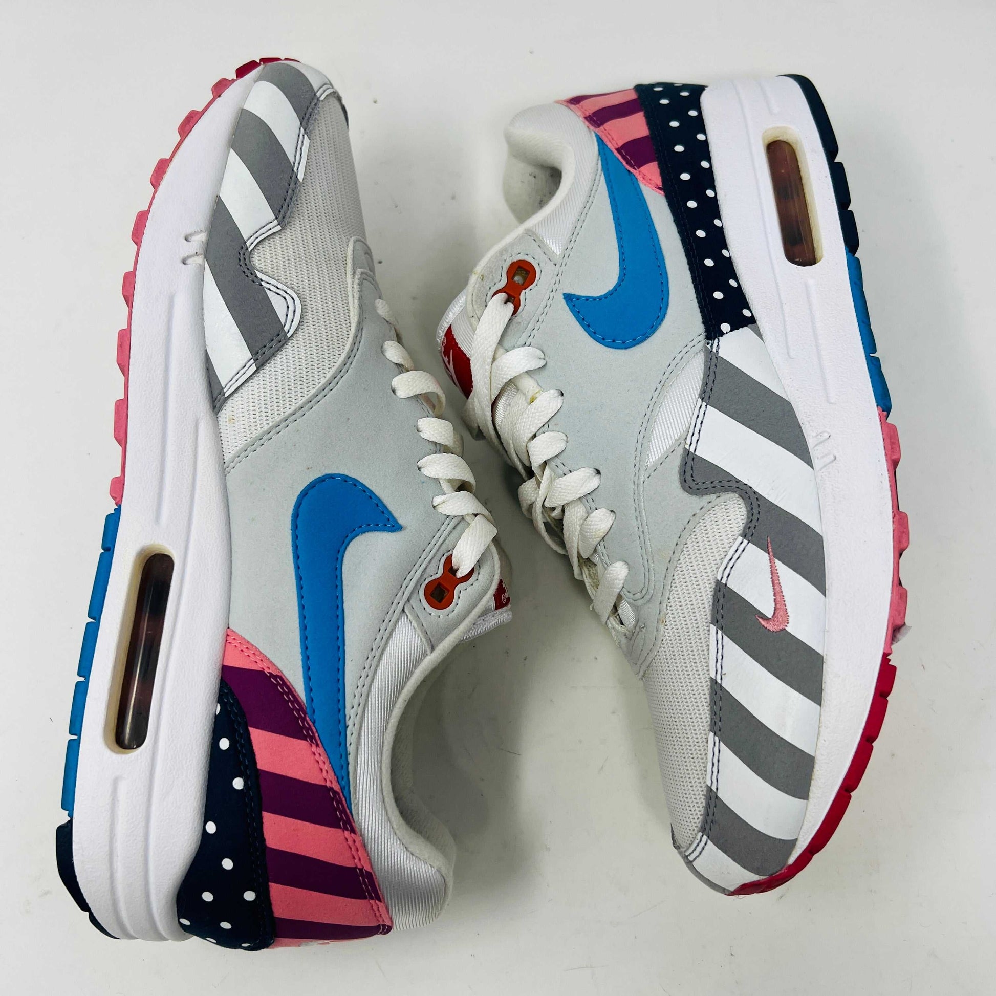 A Nike Air Max 1 Parra (2018) sneaker with clean uppers displaying stripes and polka dots sits on a box. The size 9.5 shoe features a blue swoosh and red, white, black accents, with visible original and discounted price tags ensuring authenticity.