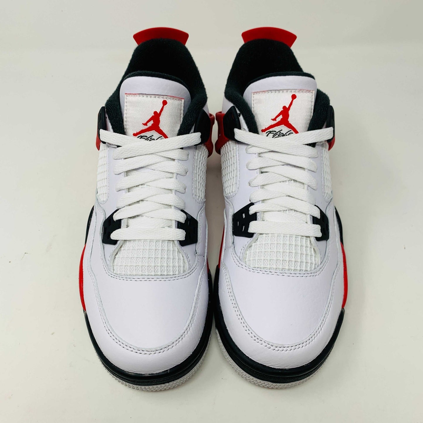 Jordan 4 Retro Red Cement (GS) sneakers with bold red and cement grey accents.