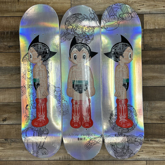 Astro Boy x Bait Atom Project Glow Skateboard Deck Set Silver on wooden background.