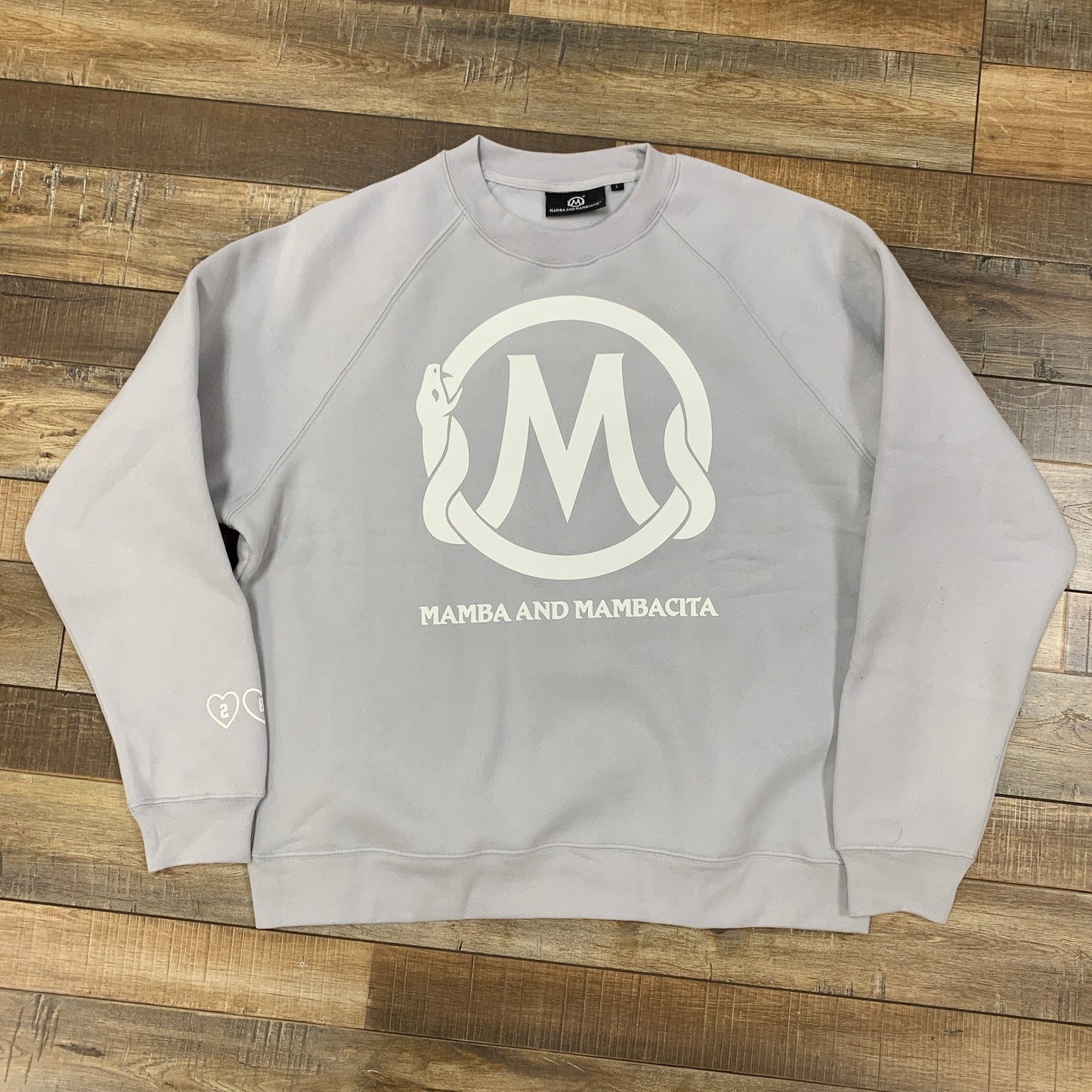 MAMBA ACADEMY Set Grey sweatshirt, brand new with logo design on front, placed on wooden floor.