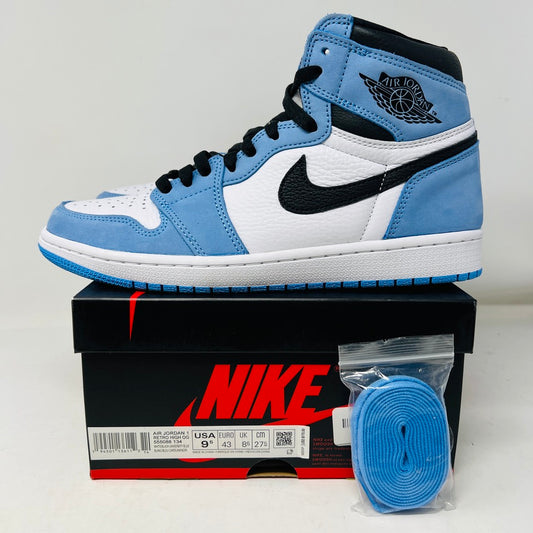 The Jordan 1 Retro High OG University Blue sneaker sits atop a Nike shoebox, showcasing its light blue, white, and black high-top design with a prominent black Nike swoosh. Beside the box is a sealed pack of extra light-blue laces.