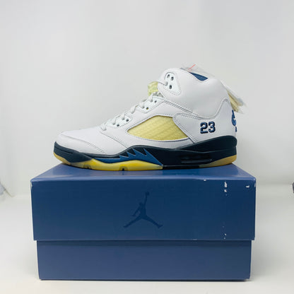 Women's Jordan 5 Retro A Ma Maniére Dawn sneakers in white, black, and gold on display box.