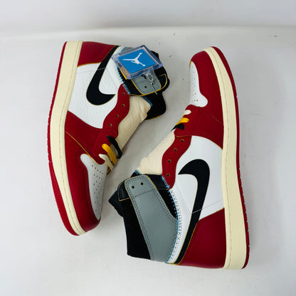 The Jordan 1 Retro High OG SP Union LA Chicago Shadow sneaker, featuring red, white, and gray sections with a black Nike swoosh, is displayed on a shoebox covered in shoe images. This BRAND NEW 2025 sneaker includes detailed stitching, a visible yellow tag, and comes with EXTRA LACES.