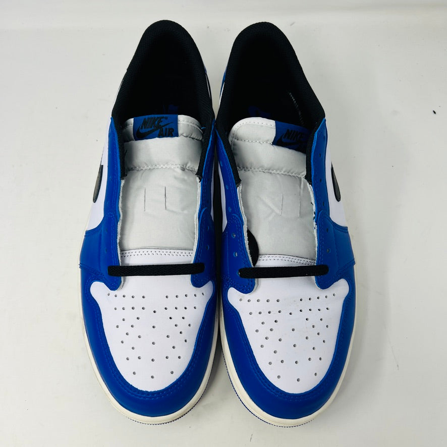 A Jordan 1 Retro Low OG Game Royal shoe in blue, white, and black is showcased on a matching blue Nike box. It features a black swoosh logo and the box label indicates size 12.