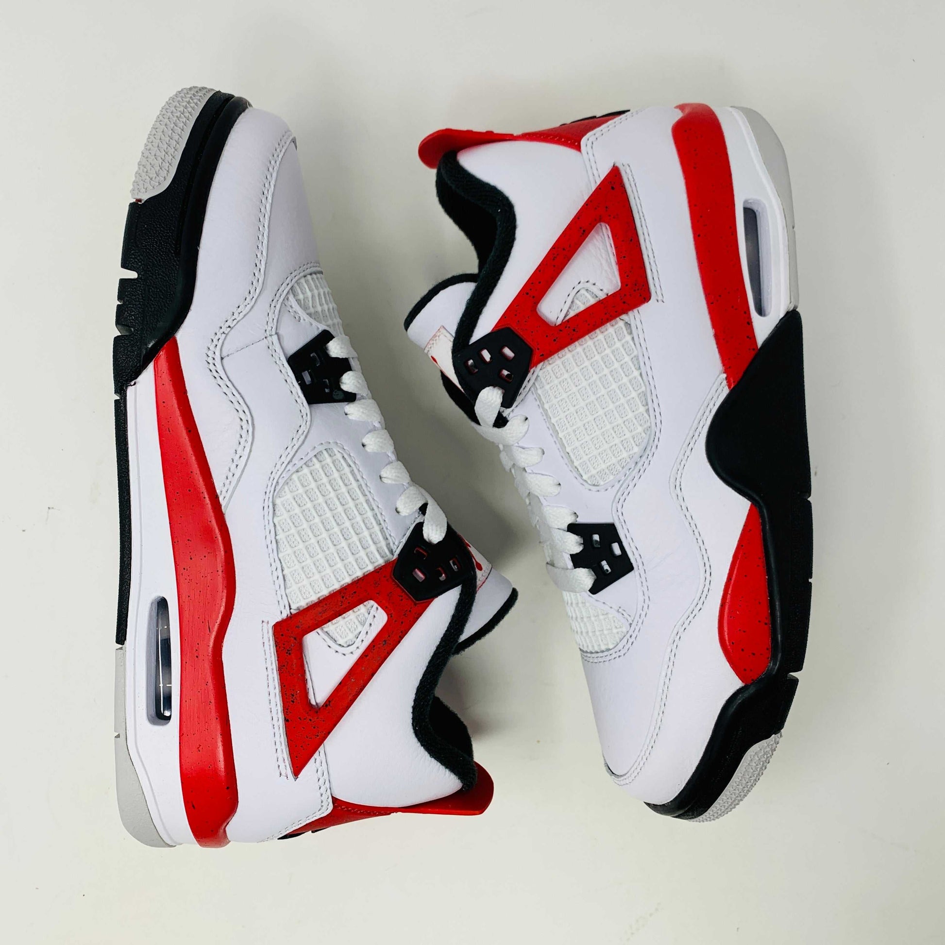 Jordan 4 Retro Red Cement GS sneakers with red and cement grey accents.