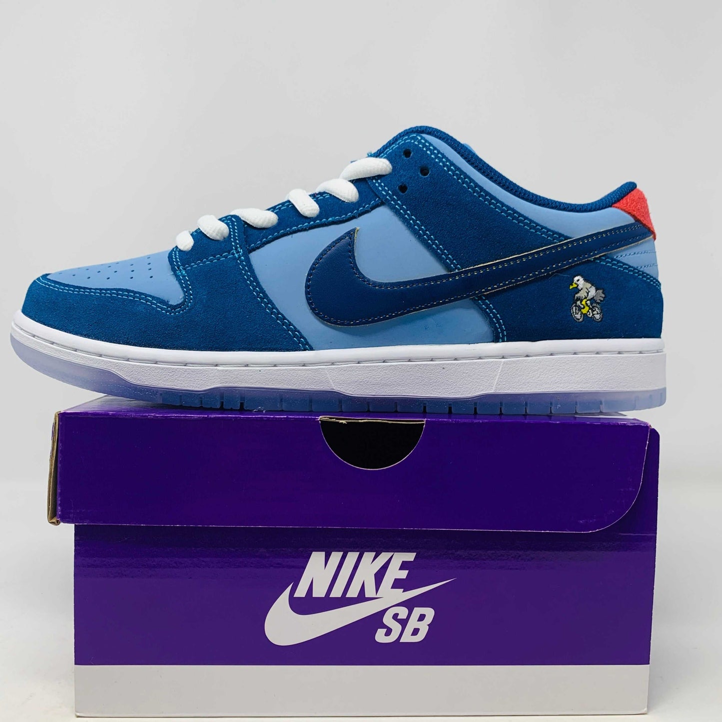 Nike SB Dunk Low "Why So Sad?" sneakers on box, blue and white colorway.