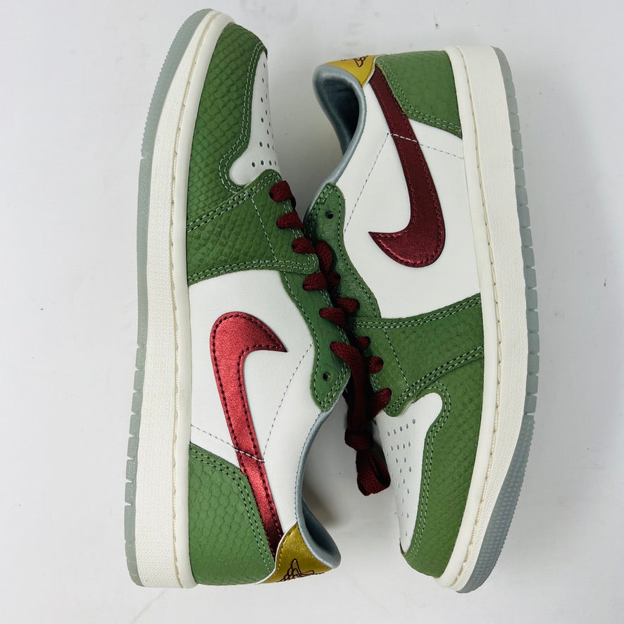 The Jordan 1 Retro Low OG Year of the Dragon (2024) features a white base with green and red accents, gray soles, red laces, a metallic red swoosh logo, a textured green pattern, and a small yellow detail near the heel.