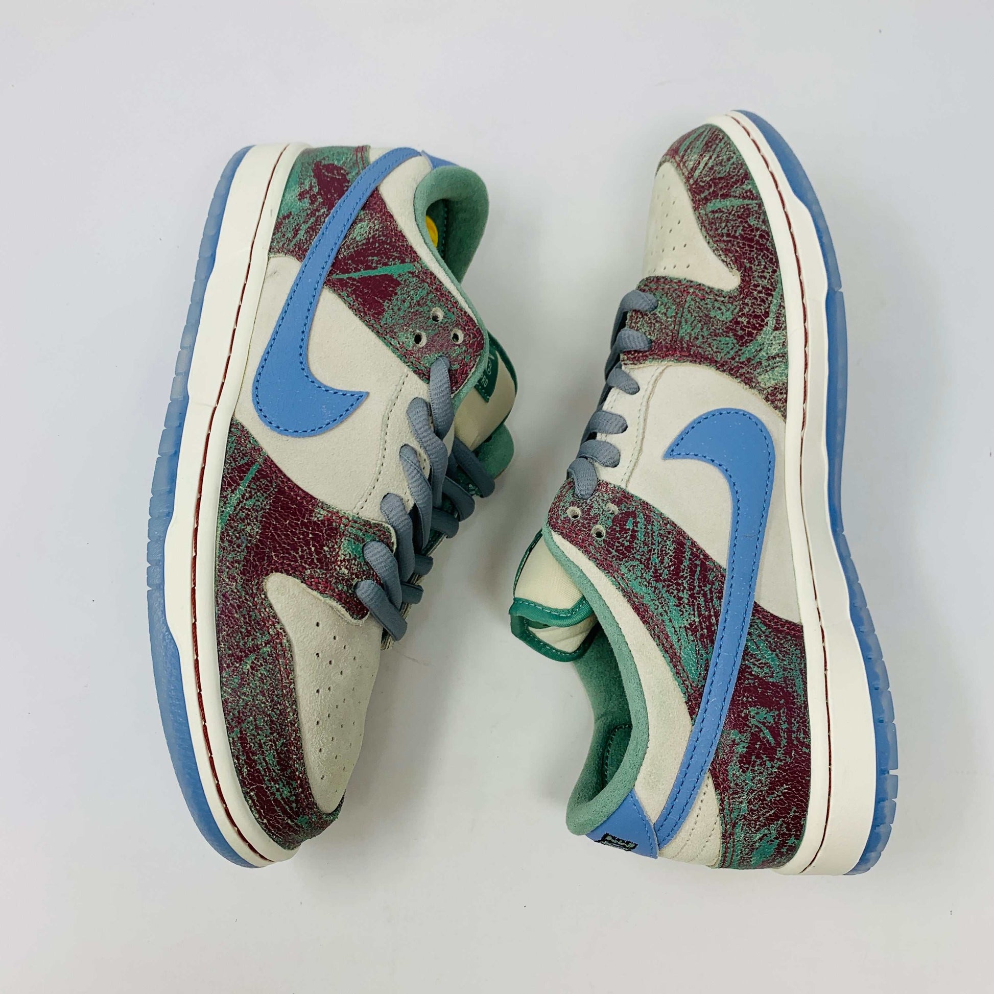 Nike SB Dunk Low Crenshaw Skate Club sneakers with blue Swoosh and red-green pattern.