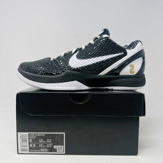 The black and white Nike Kobe 6 Protro Mambacita Sweet 16 shoe features a glossy finish, a gold number 2 on the heel, and light wear with a minor scratch on the back tab. It comes in sizes 8 and 9.5, displayed on a black box labeled Kobe V Proto, and is guaranteed authentic by KOBE.