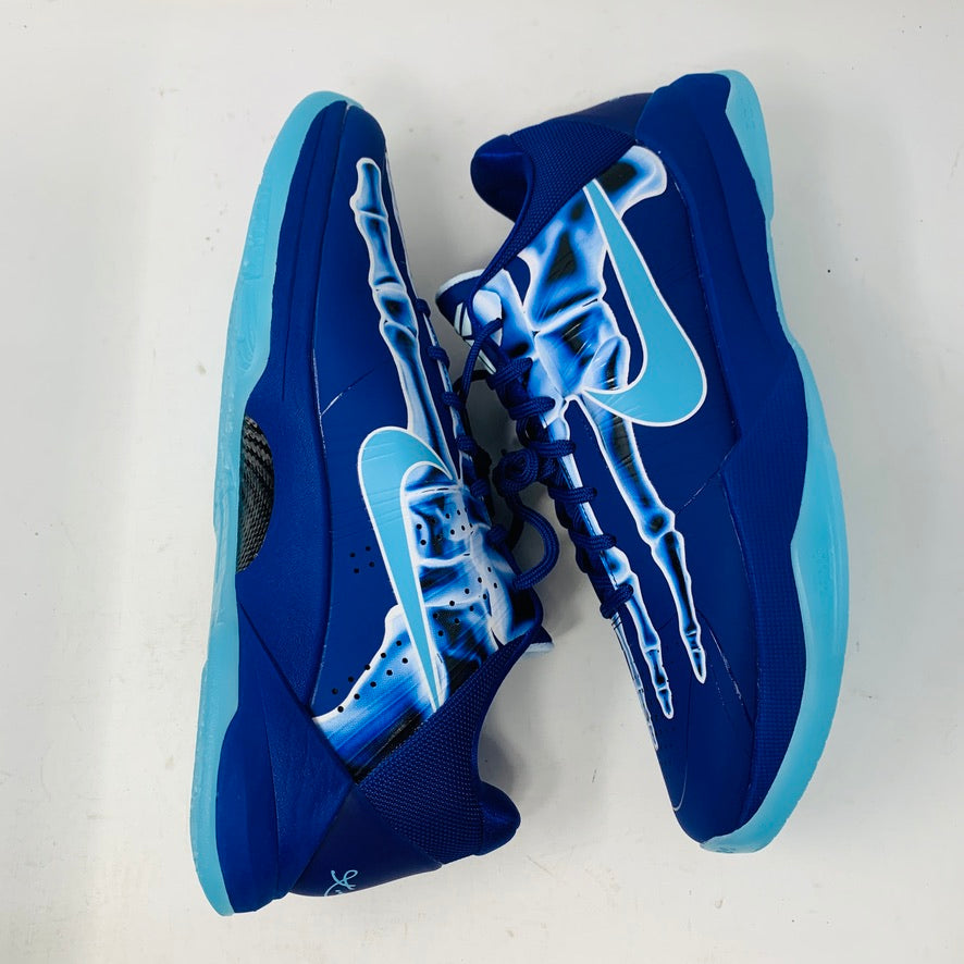 The Nike Kobe 5 Protro X-Ray sneakers are blue with light blue soles and accents, featuring white stylized skeletal graphics on the sides for a unique artistic flair.