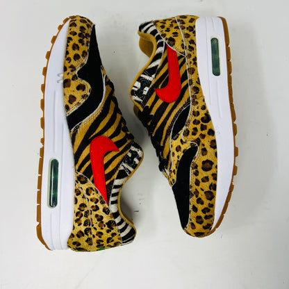 The Nike Air Max 1 Atmos Animal Pack 2.0 features a bold animal print with leopard and zebra patterns, a prominent red swoosh on the side, white midsoles, and gum soles, creating an eye-catching look.