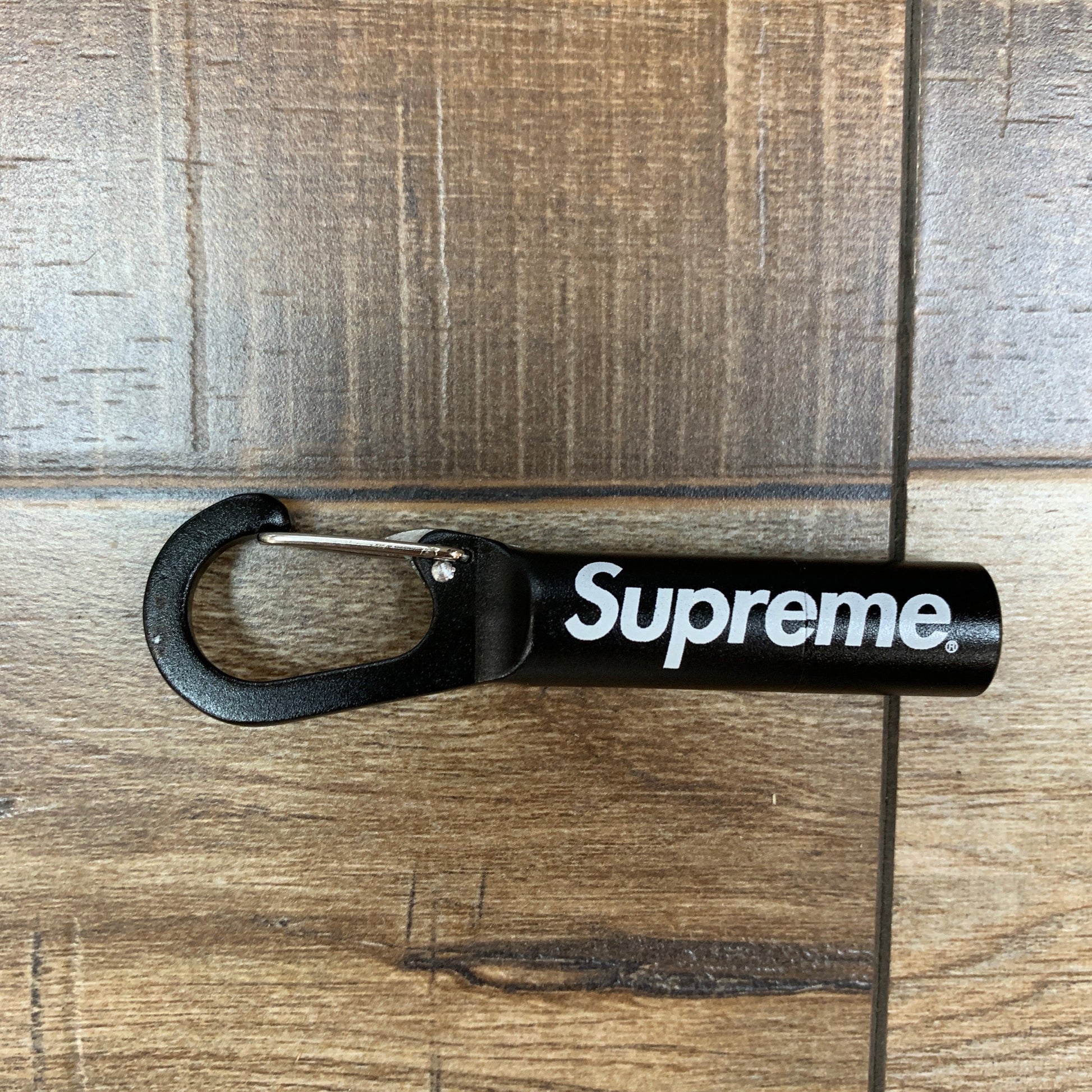 Supreme Stash Pill Carabiner in black, featuring the Supreme logo, brand new condition.