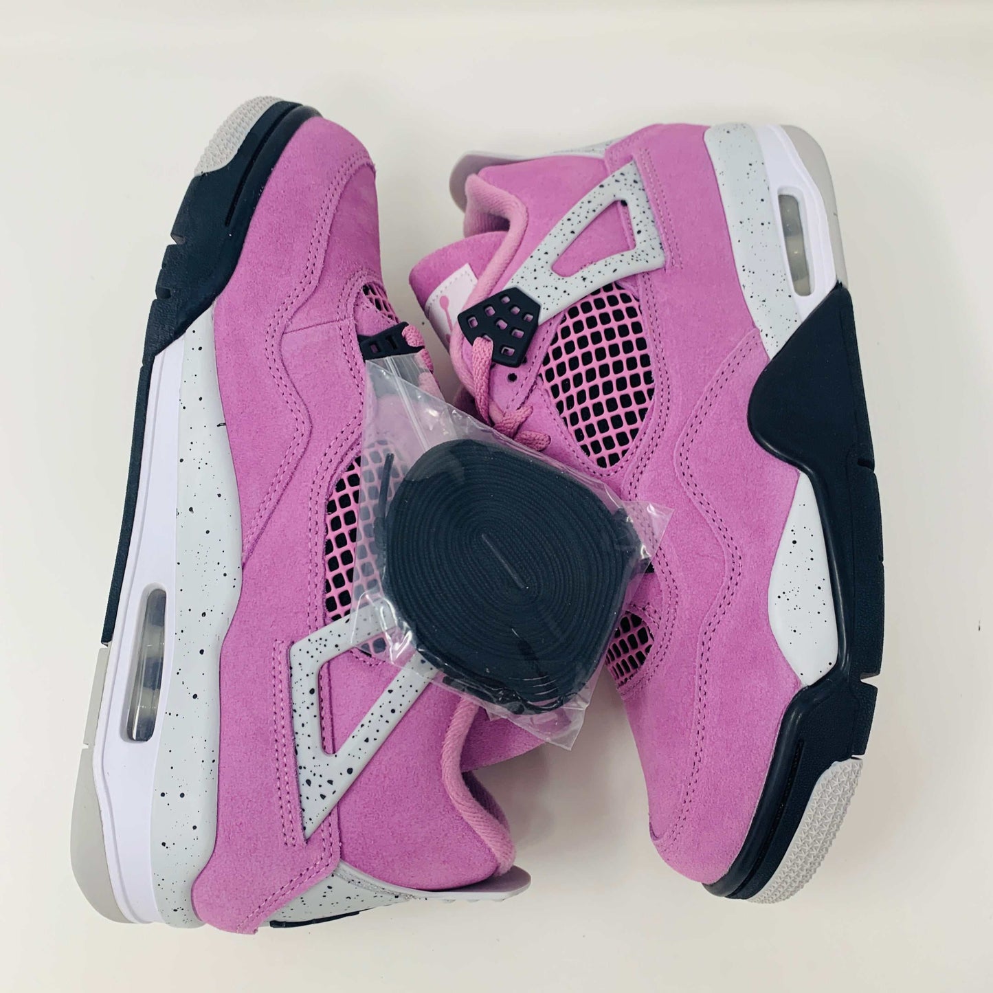 Women's Jordan 4 Retro Orchid sneakers in pink with premium materials.