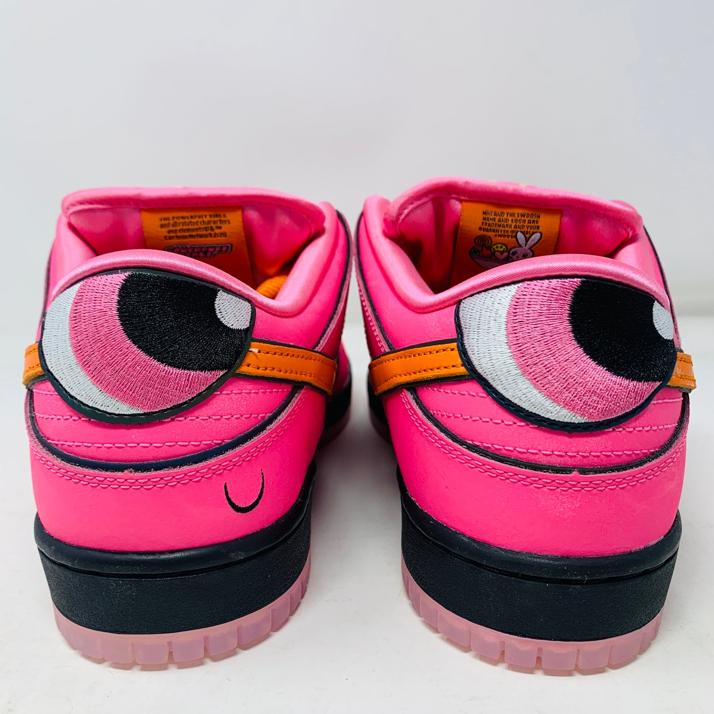 Nike SB Dunk Low The Powerpuff Girls Blossom sneaker with pink, green, and black colorway, displayed on a box.