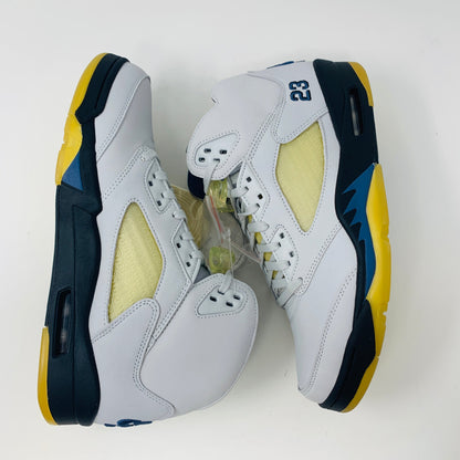 Women's Jordan 5 Retro A Ma Maniére Dawn sneakers in white, black, and gold with Jordan logo.