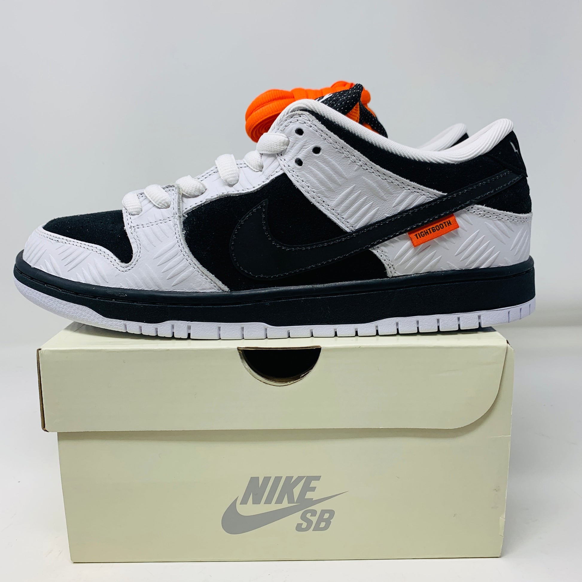 Nike SB Dunk Low TIGHTBOOTH sneakers on box with orange and black laces, 2023 release.