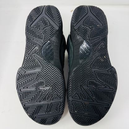 The Nike Kobe 4 Protro Gift of Mamba, a black athletic shoe with clean uppers and a reptile-like texture, is shown on its box. It features the iconic swoosh and a visible Zoom Air unit in the heel. The box label includes shoe size and product details.