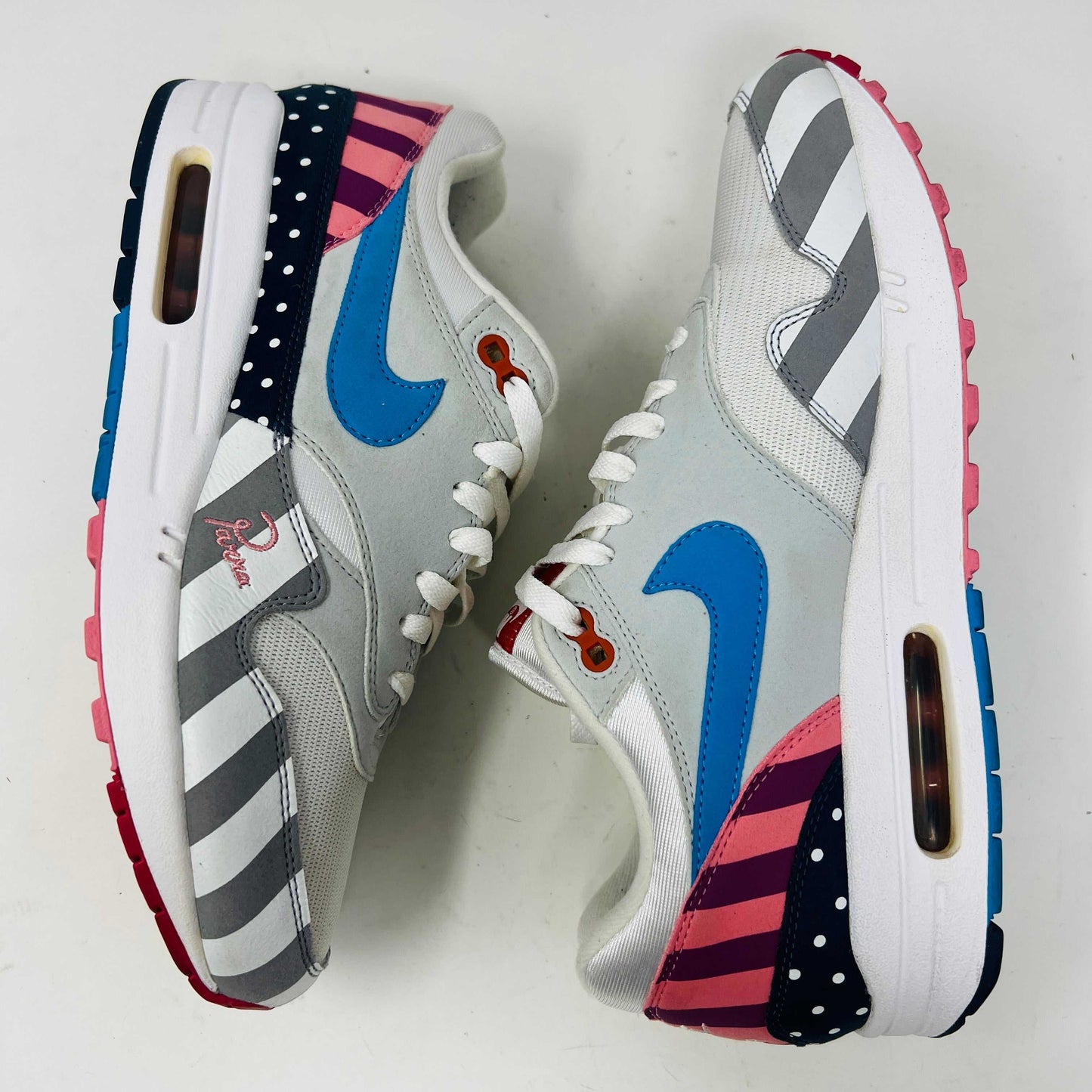 A Nike Air Max 1 Parra (2018) sneaker with clean uppers displaying stripes and polka dots sits on a box. The size 9.5 shoe features a blue swoosh and red, white, black accents, with visible original and discounted price tags ensuring authenticity.