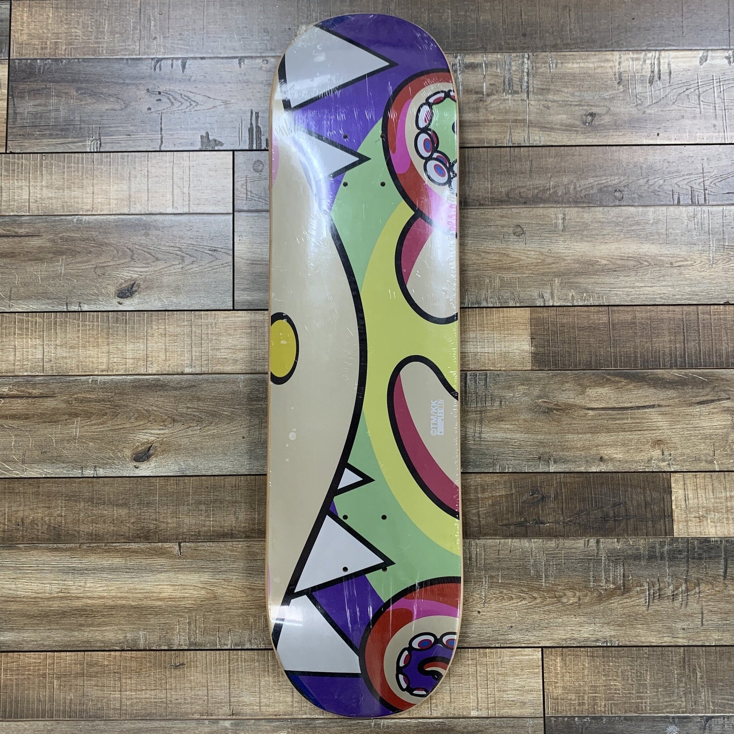 Takashi Murakami Octopus Skateboard Deck Set on wood floor.