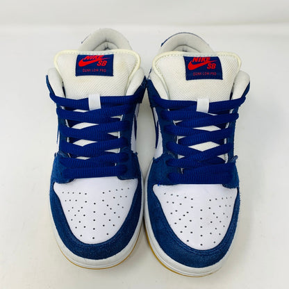 A top-down view of Nike SB Dunk Low Los Angeles Dodgers sneakers features blue and white colors, blue laces, and red branding on the tongue against a white background.