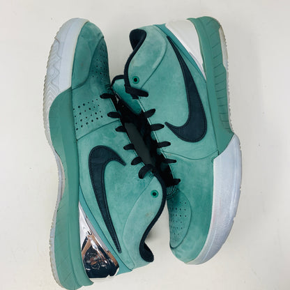 A pair of Nike Kobe 4 Protro Girl Dad shoes, featuring a sleek design with green uppers, black swoosh logos, white midsoles, and green outsoles sits on a white surface. They have perforations for ventilation and a metallic detail on the heel.