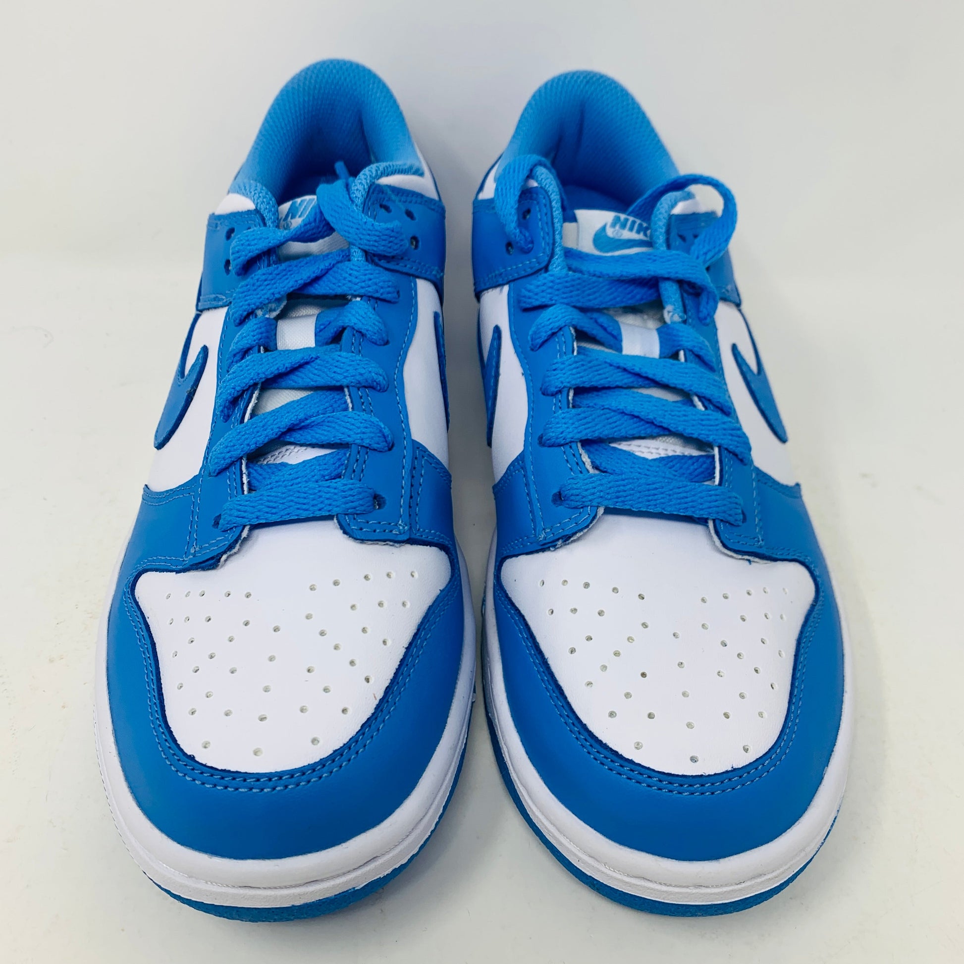 Nike Dunk Low UNC GS sneakers in blue and white, brand new condition, front view.