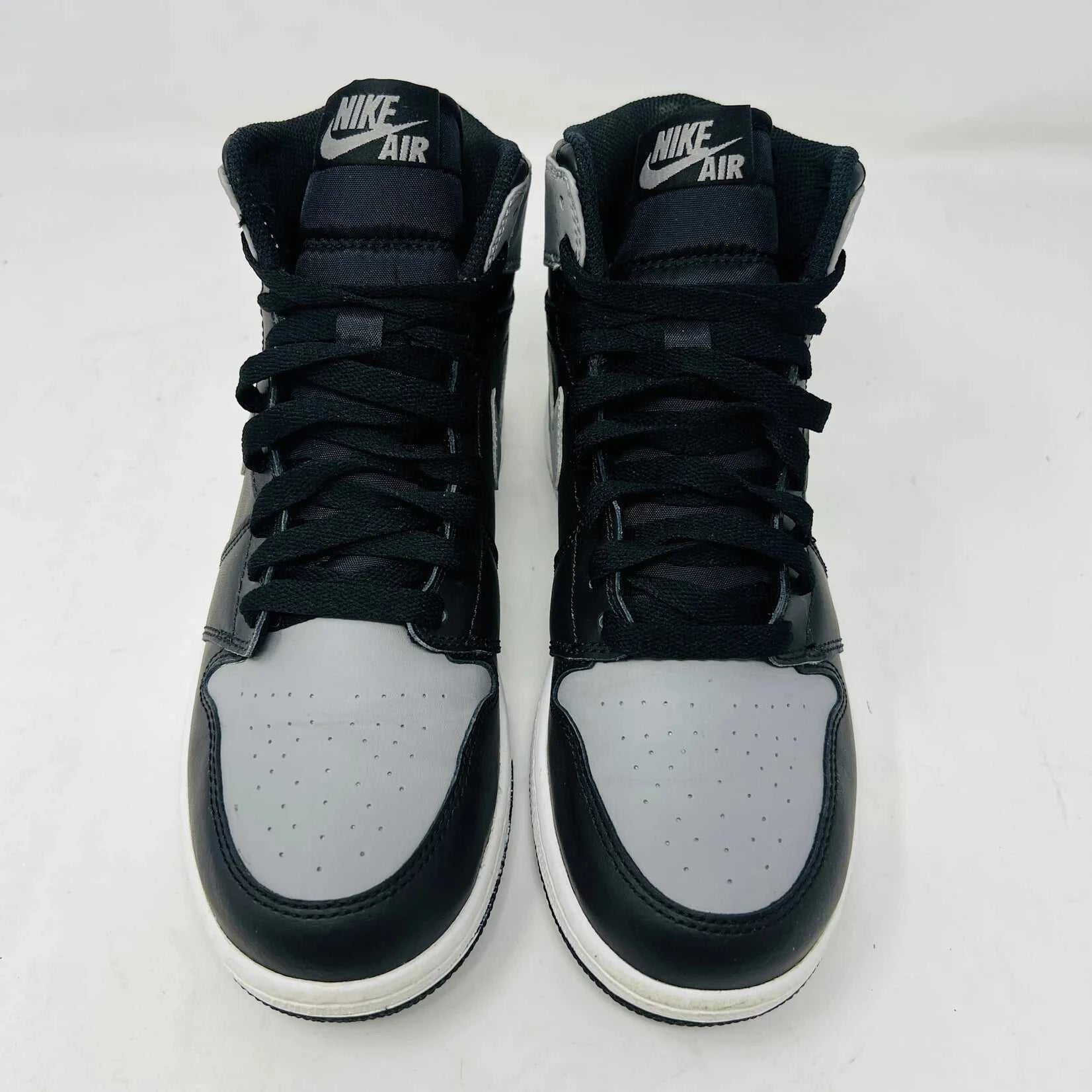 A Jordan 1 Retro Shadow (2013) (GS) sneaker in black and gray, featuring the Air Jordan logo on the collar, rests on its box. The box is black with the iconic red Nike logo. Price: $425 USD.