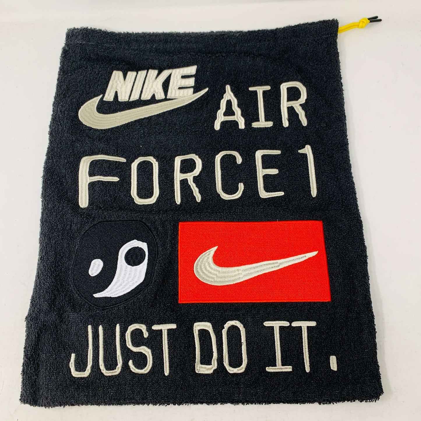 Black dustbag with Nike Air Force 1 and Cactus Plant Flea Market logos, featuring a yin-yang design and "Just Do It" text.