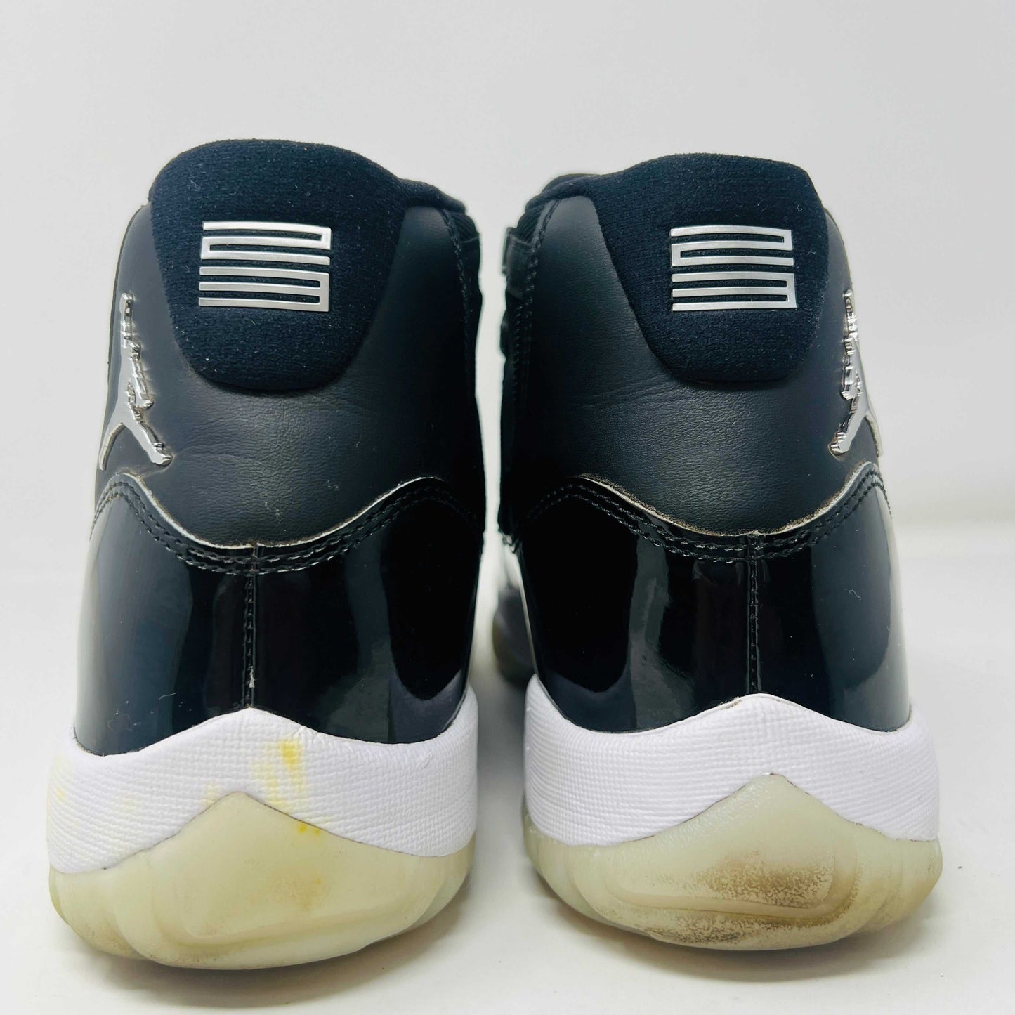 Jordan 11 Retro Jubilee 25th Anniversary sneakers, size 11, black and white, back view showing heels.