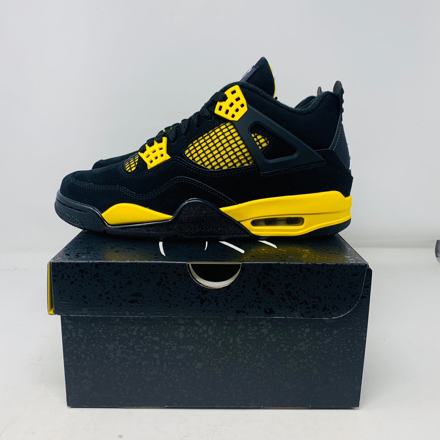 Jordan 4 Thunder 2023 sneaker in black and yellow on box.