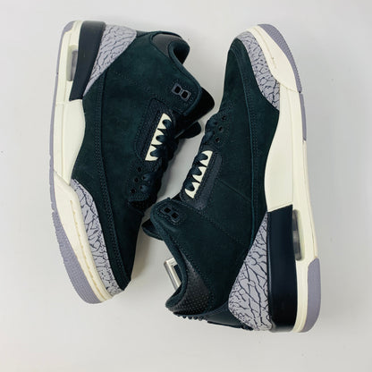 The Jordan 3 Retro Off Noir (W) sneakers feature a black and gray design with white midsoles, complemented by gray speckled patterns on the heels and near the laces, displayed on a white background.