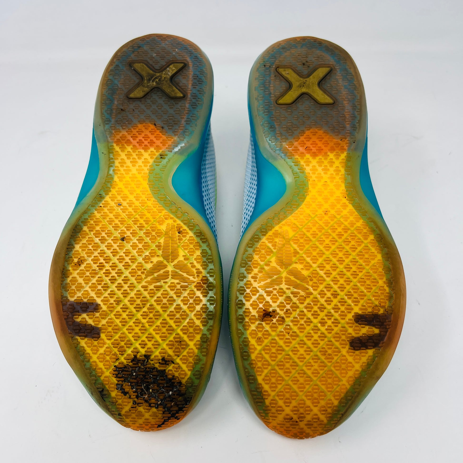 The Kobe 10 GS High Dive from Nike, in size 7Y, is on display with a blue upper, gradient yellow-green Swoosh, orange lining, and a multicolored sole. Its resting on its black box and shows normal wear.