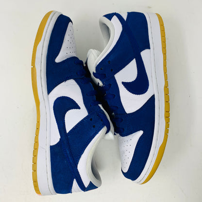 The Nike SB Dunk Low Los Angeles Dodgers showcases a 2022 design with a white and blue color scheme, featuring the iconic swoosh logo, white laces, and yellow rubber soles. Artfully arranged on a plain white background with one shoe facing up and the other down.