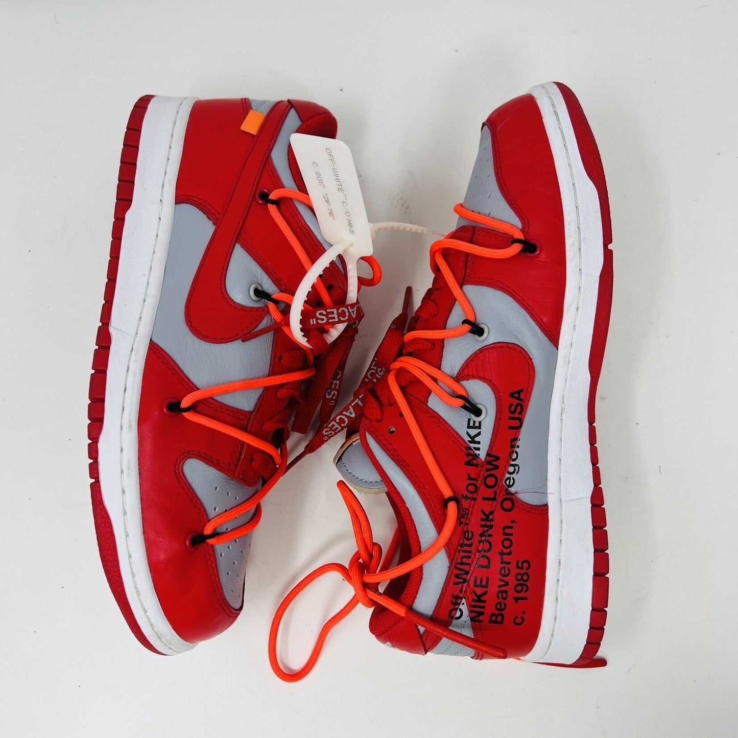 The Nike Dunk Low Off-White University Red sneakers with orange laces, from Holy Ground, are clean and authentic, showcased atop a white shoebox displaying size and product details.