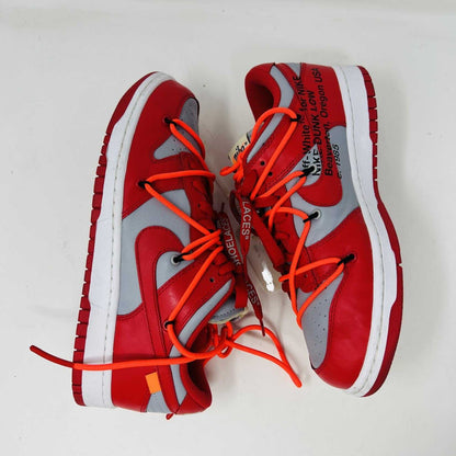 The Nike Dunk Low Off-White University Red sneakers with orange laces, from Holy Ground, are clean and authentic, showcased atop a white shoebox displaying size and product details.