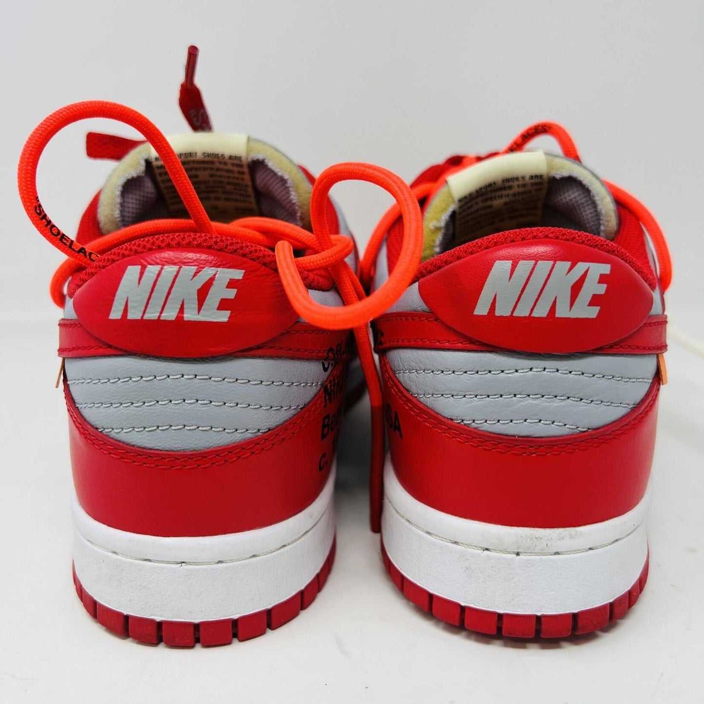 The Nike Dunk Low Off-White University Red sneakers with orange laces, from Holy Ground, are clean and authentic, showcased atop a white shoebox displaying size and product details.