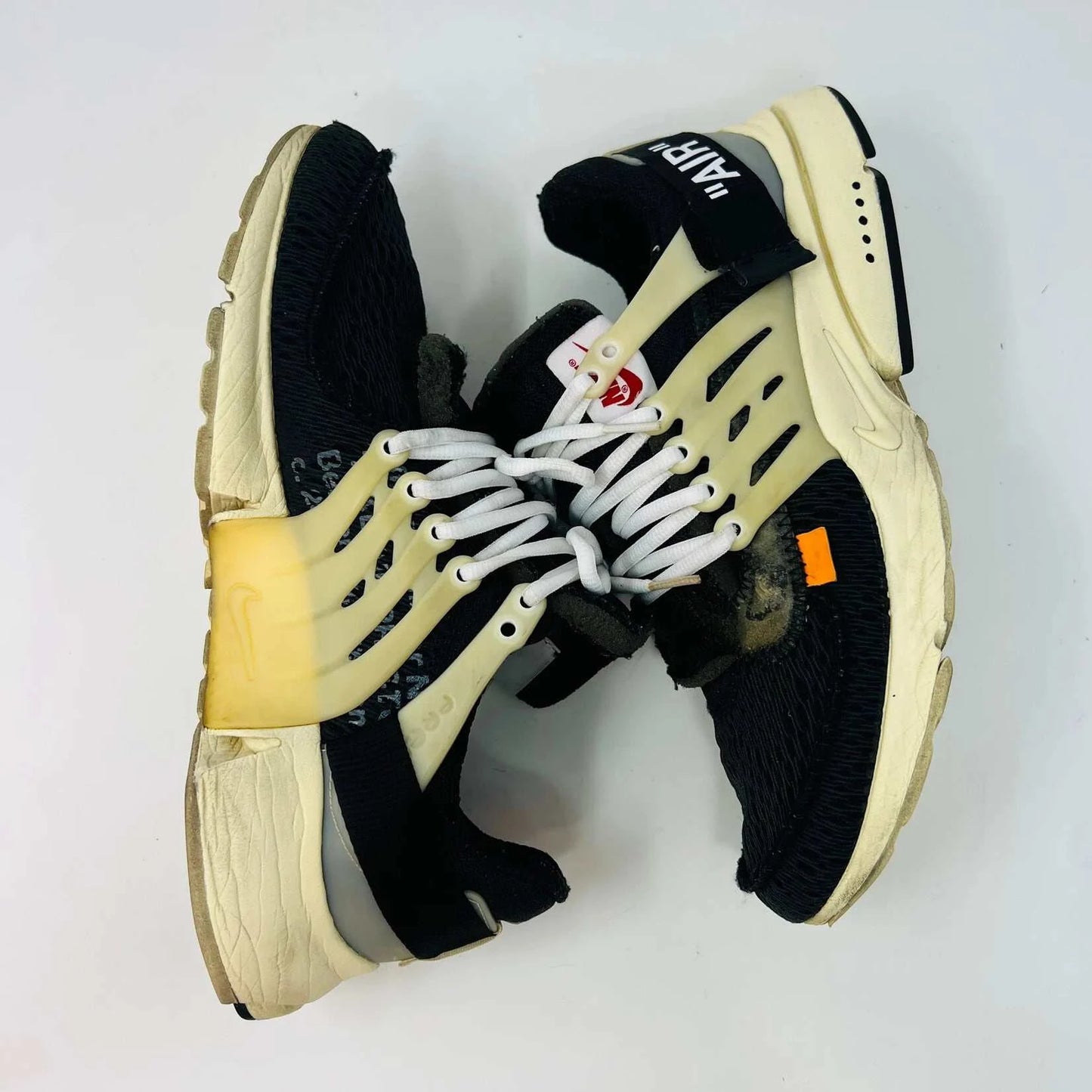 Black and beige Nike Air Presto Off-White sneakers, 8/10 condition and 100% authentic. Features extra orange, neon green, and black laces, plus a red zip tie. Displayed on a shoebox with AIR text.