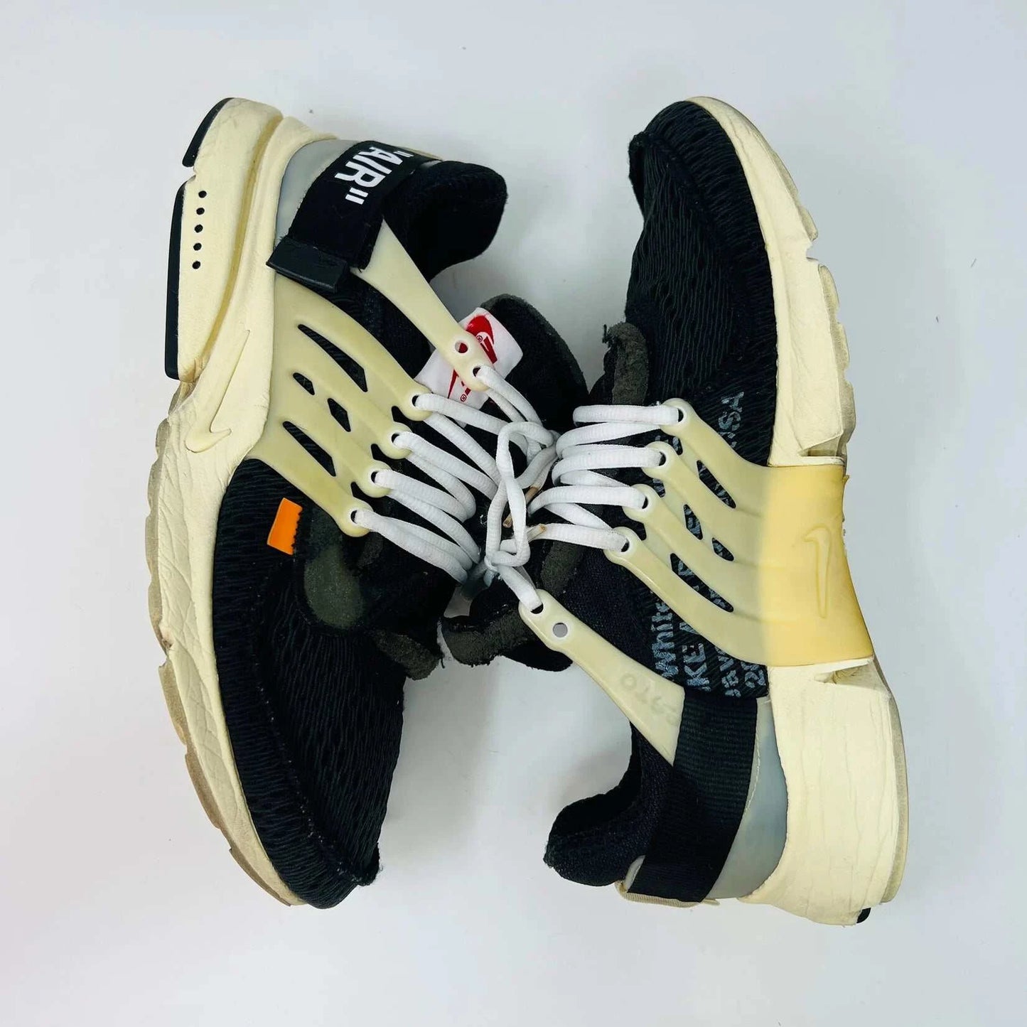 Black and beige Nike Air Presto Off-White sneakers, 8/10 condition and 100% authentic. Features extra orange, neon green, and black laces, plus a red zip tie. Displayed on a shoebox with AIR text.